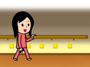 夜、足元灯がある明るい廊下を歩く人
